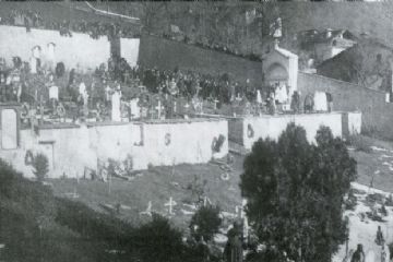10 gennaio 1918<br>Sepoltura del capitano Bugni, 3 medaglie d'argento al valore, morto sul fronte dell'Isonzo e trasportato a Locana.<br>Si nota la mancanza di tombe, solo croci: una sola cappella funebre, del Bugni.<br>Le donne hanno abiti/gonne lunghe e si notano inoltre i vestiti bianchi indossati dalle donne delle confraternite quando seguivano le sepolture o le processioni.